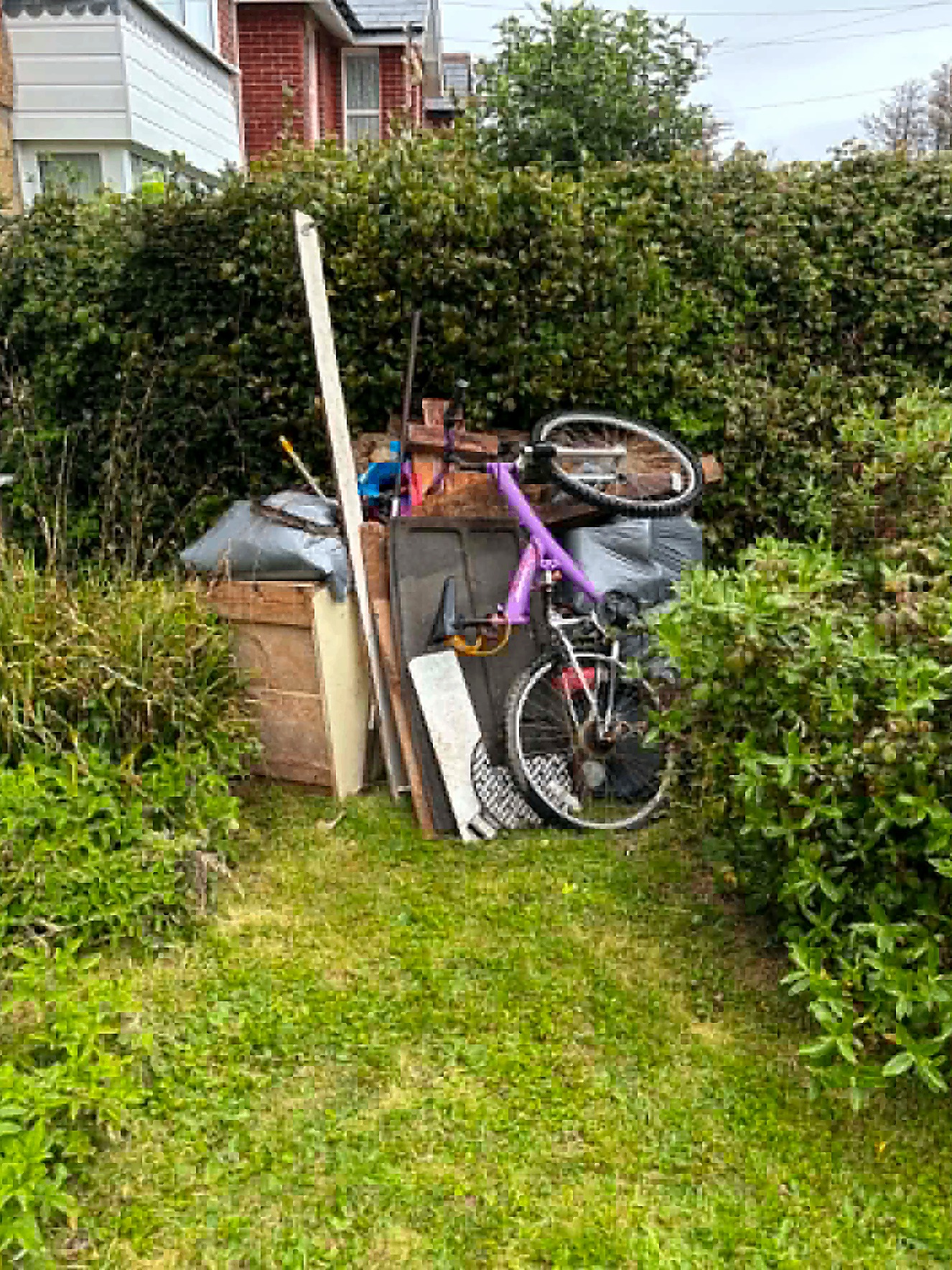 Garden waste pile with old bike ready for clearance